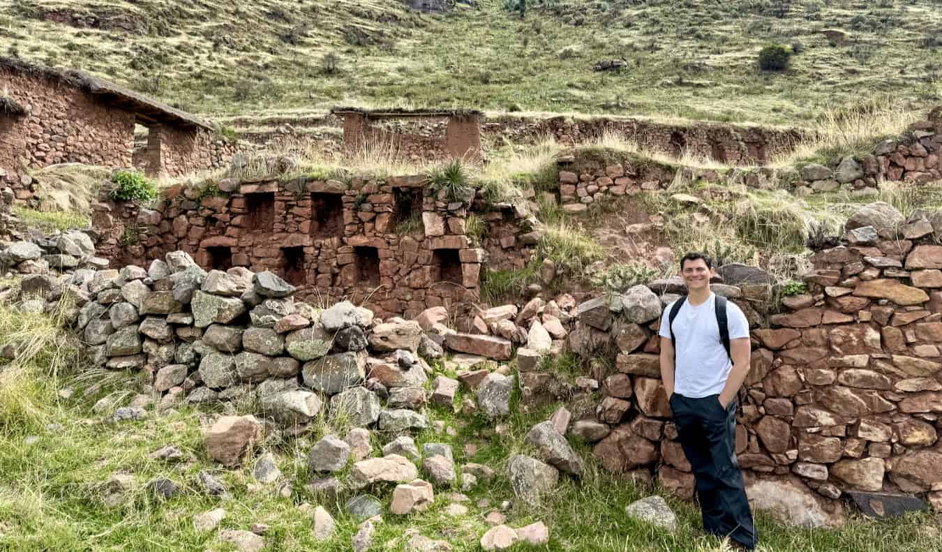 Nomadic Matt posing for a photo while hiking in the mountains of Peru on a cloudy day