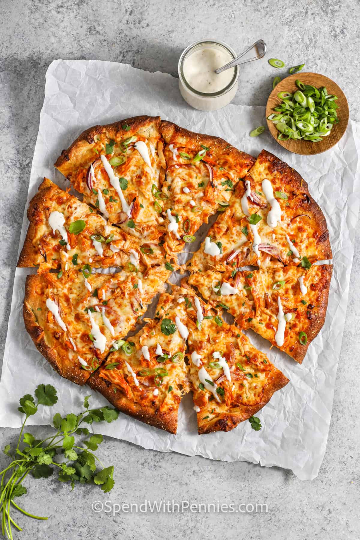 A buffalo chicken pizza cut up into slices.