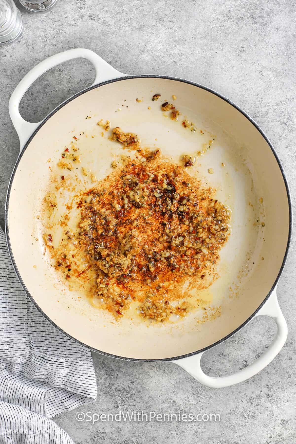 adding seasonings to oil to make Creamy Tomato Chicken Skillet