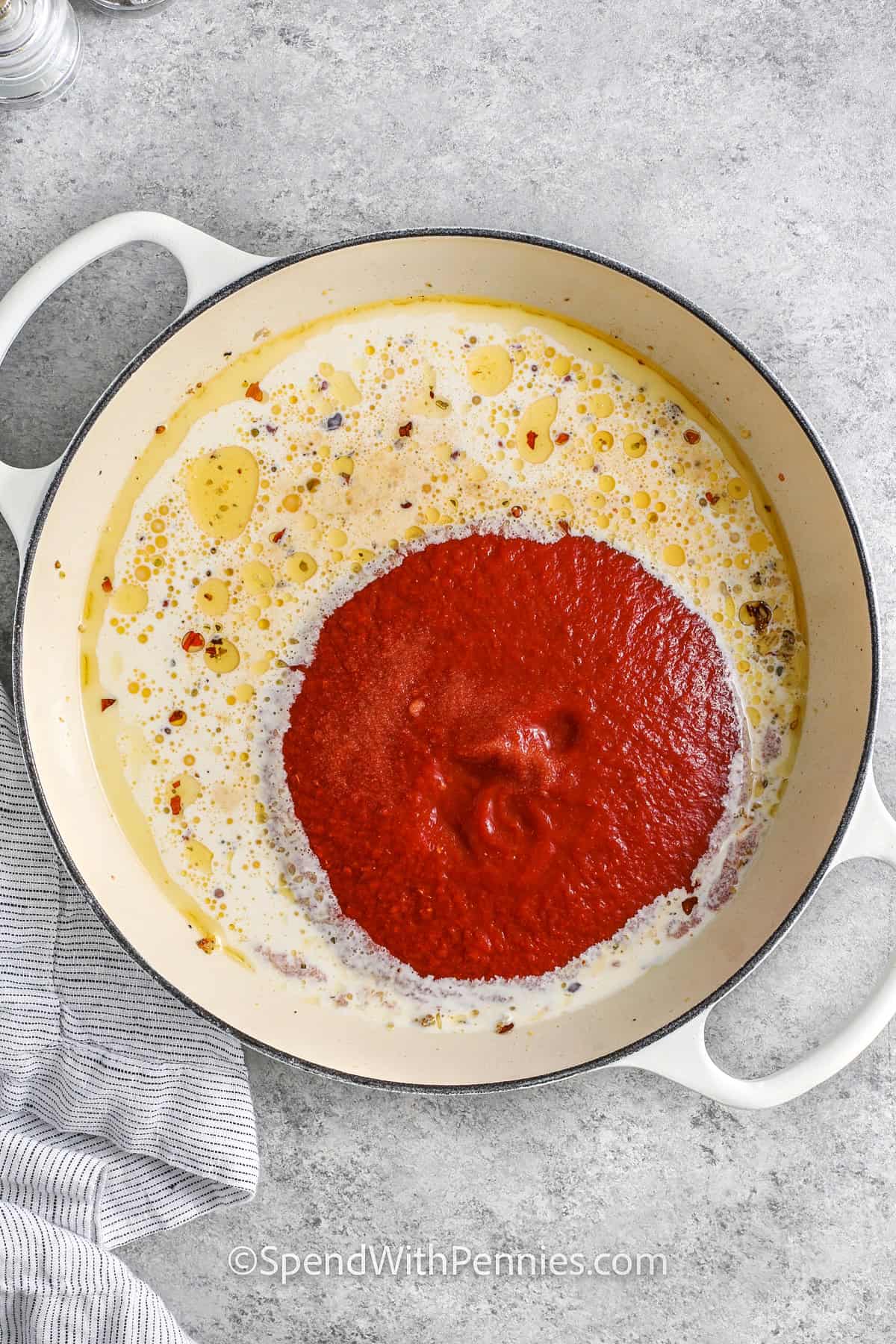 adding liquids to pot together to make Creamy Tomato Chicken Skillet