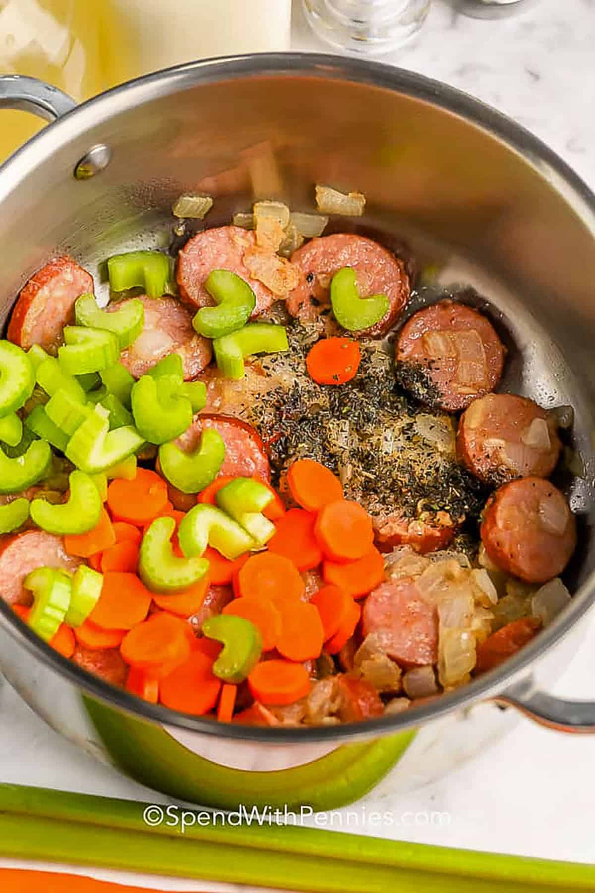 adding ingredients to pot to make Creamy Tortellini Soup