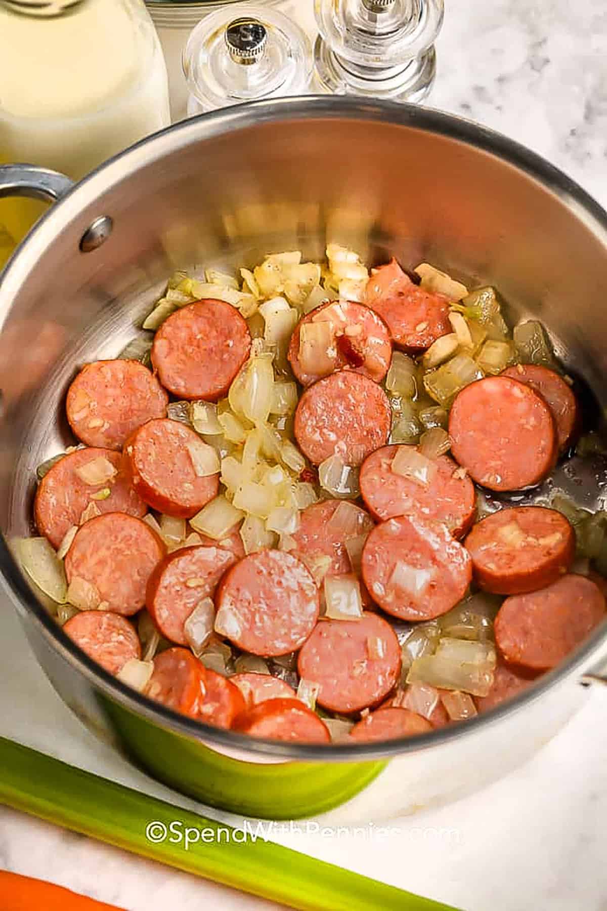 adding sausage to onions in pot to make Creamy Tortellini Soup