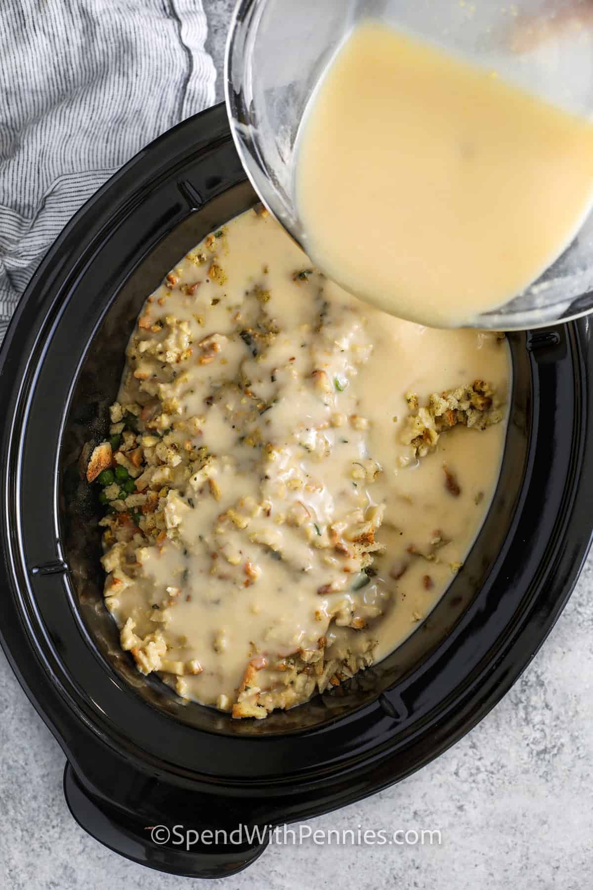 adding cream of chicken mixture to Crockpot Chicken and Stuffing