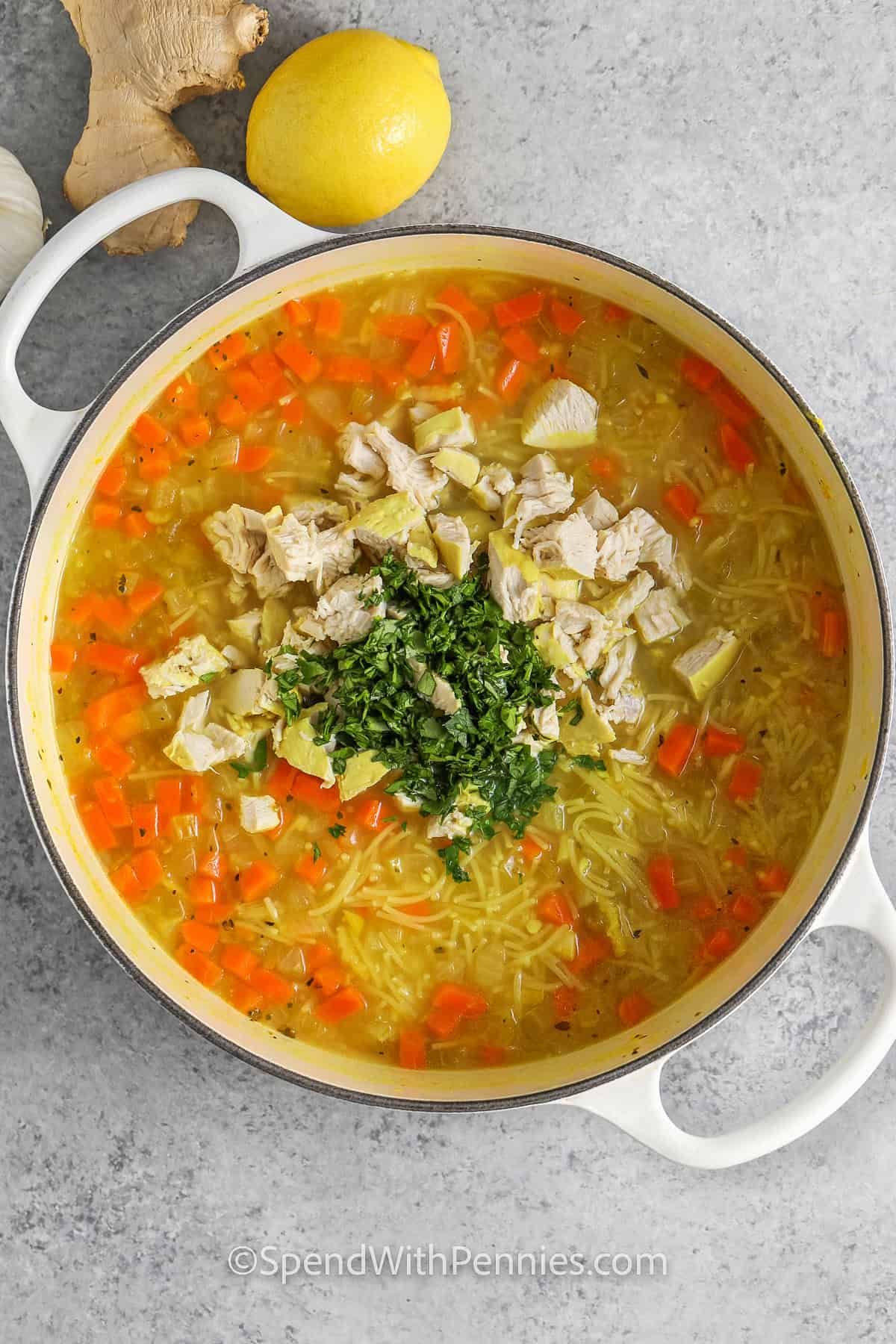 adding cut up chicken and parsley to pot to make Feel Better Chicken Soup