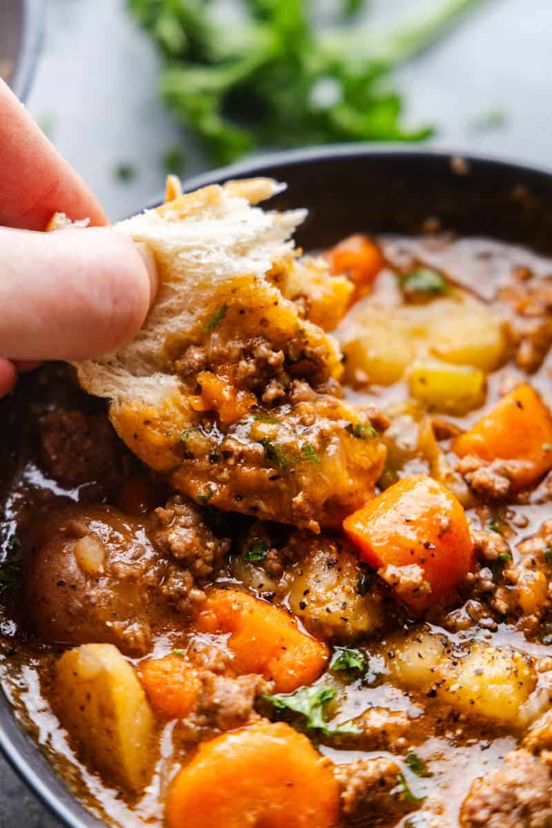 Bread being dipped into Ground beef Stew.