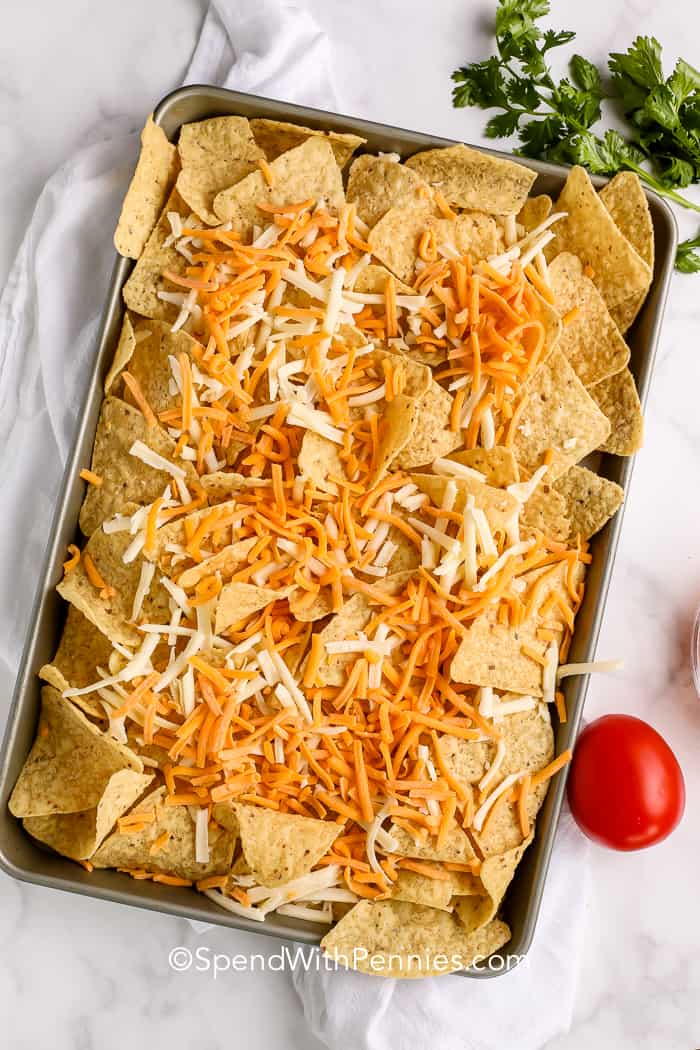 nacho chips and cheese on a sheet pan for nachos