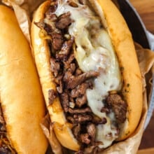 philly cheesesteak topped with cheese in a bun