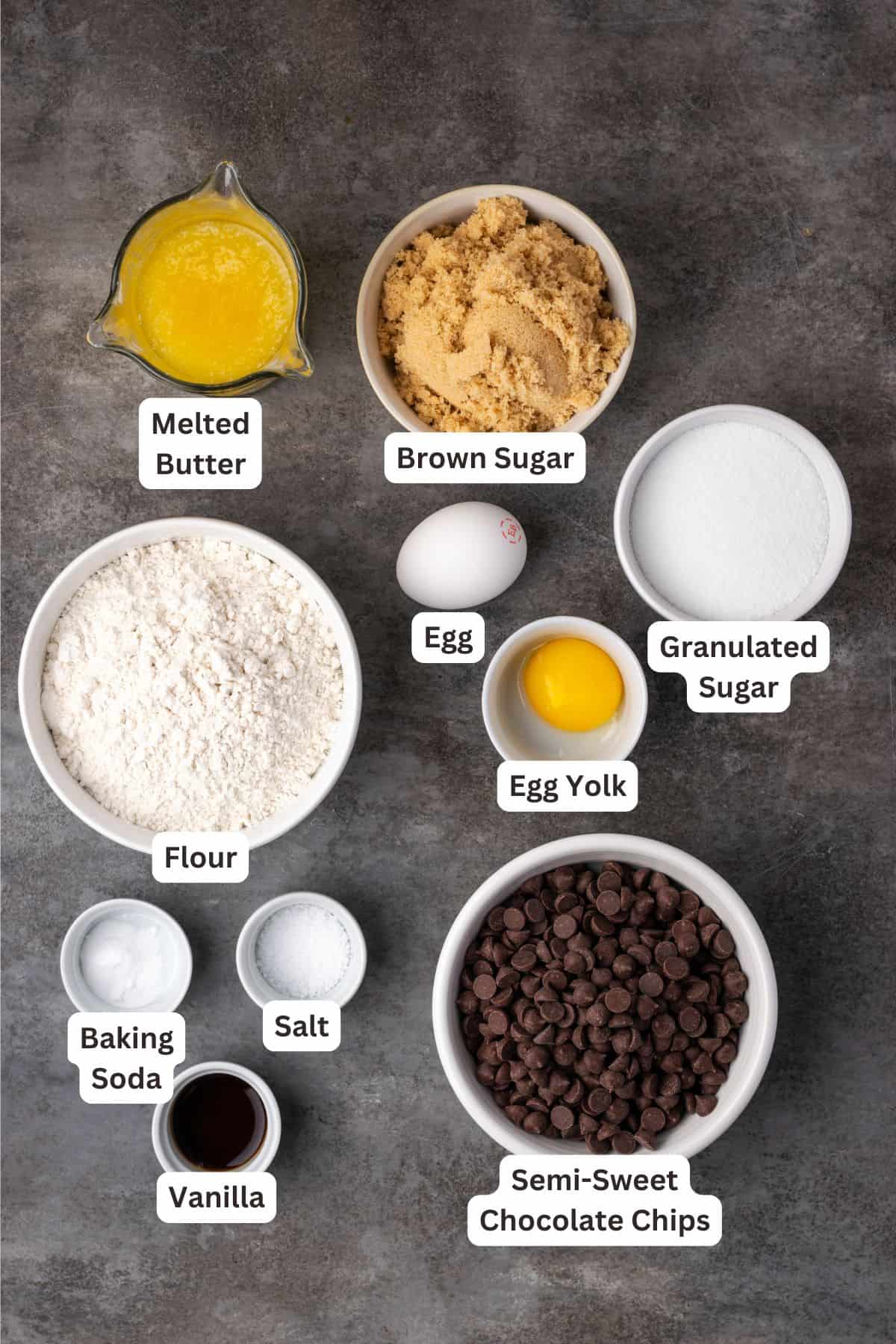 Skillet chocolate chip cookie ingredients with text labels overlaying each ingredient.