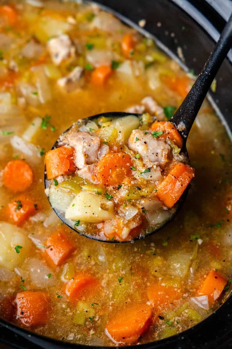 Ladle full of Slow Cooker Green Chile Pork Stew.