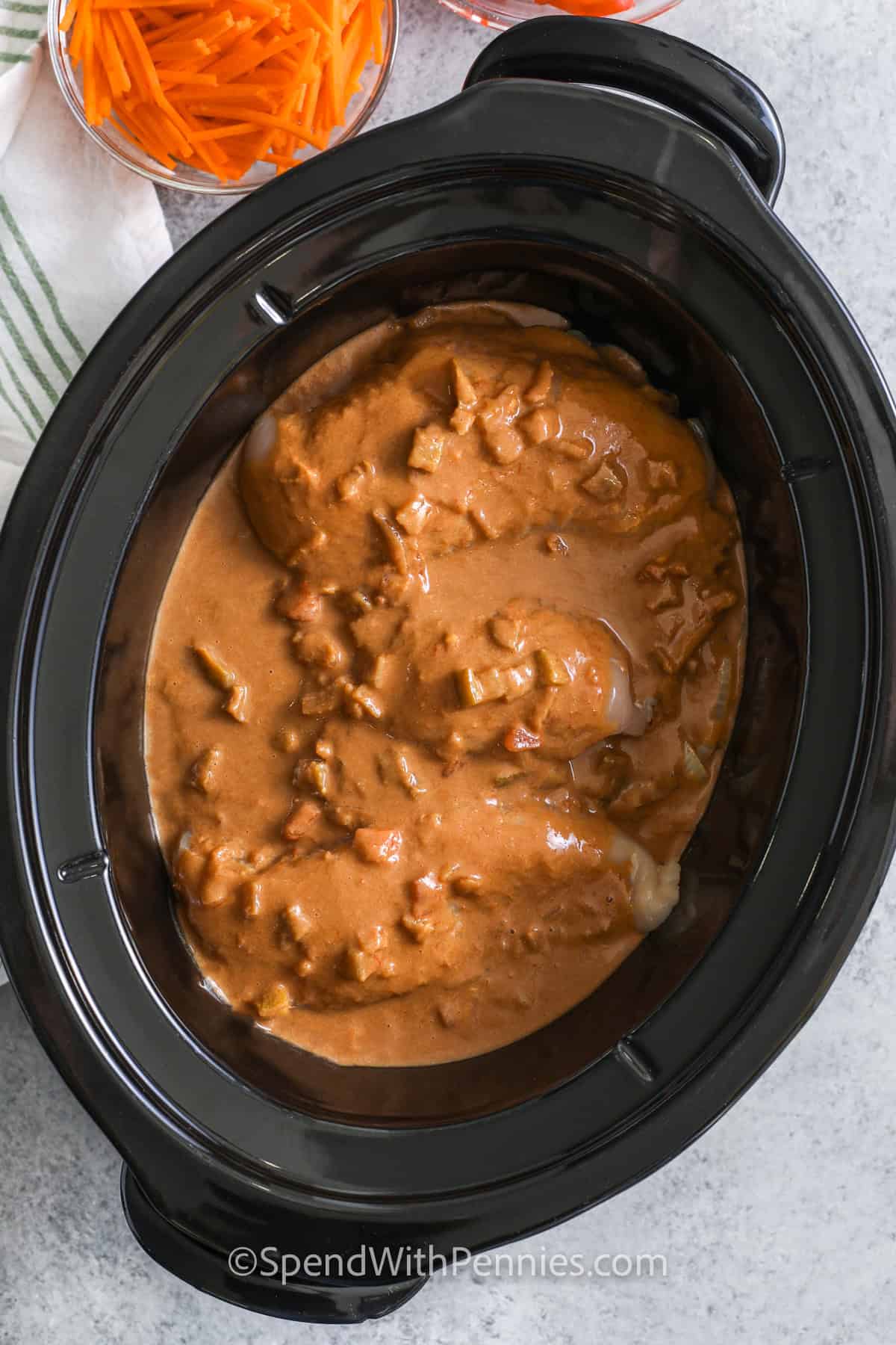 Adding sauce ingredients to a slow cooker to make peanut noodles