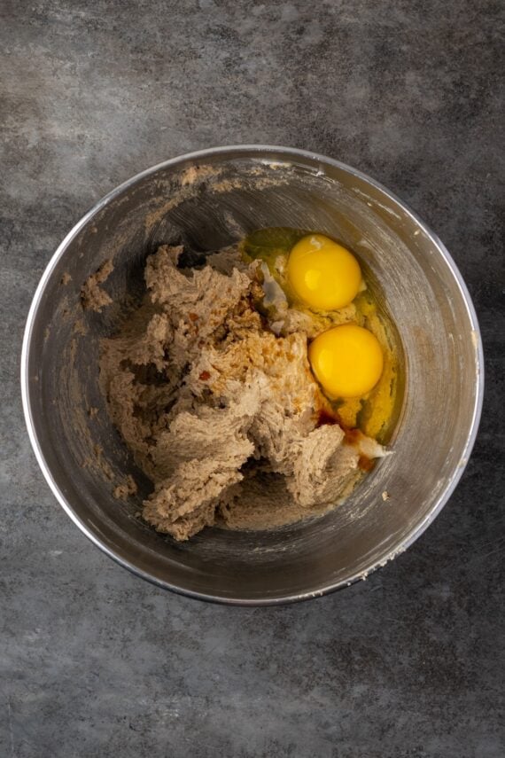 Eggs added to cookie dough in a mixing bowl.