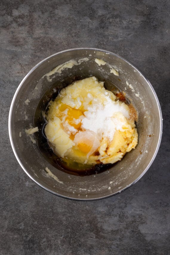 Eggs added to creamed butter and sugar in a mixing bowl.